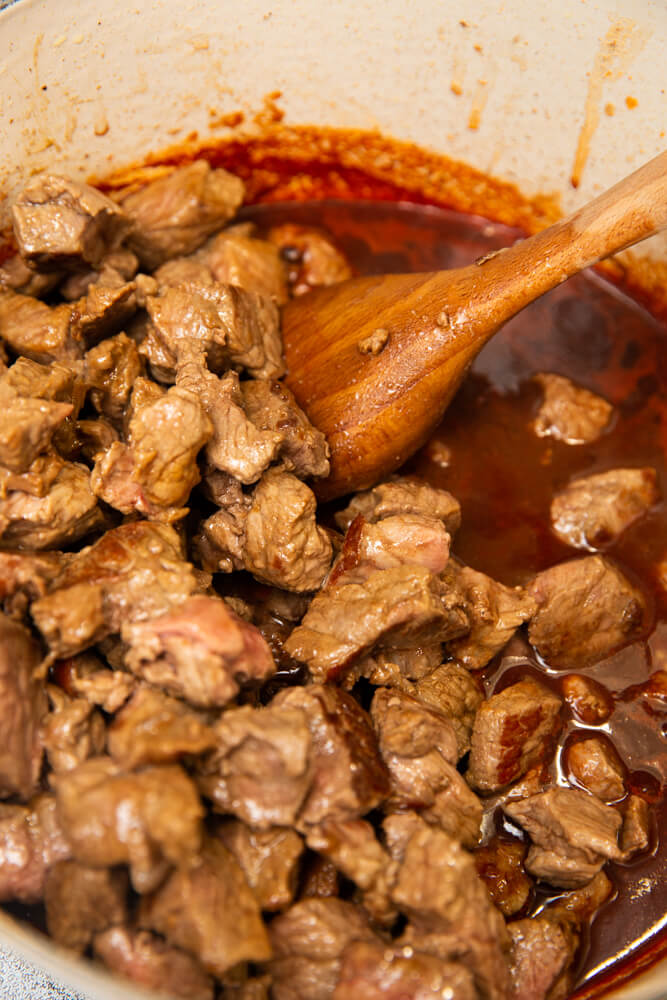 adding beef back to pot for beef stew