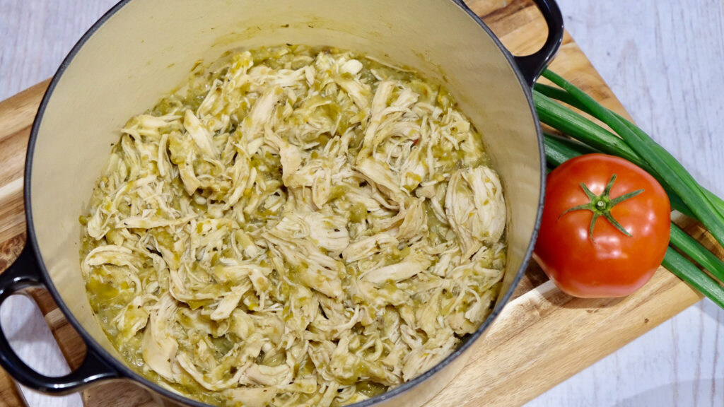 shredded chili verde chicken in a pot