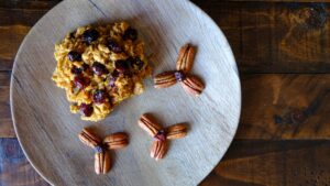 pumpkin cranberry baked oatmeal on a wood plate and dark wood background