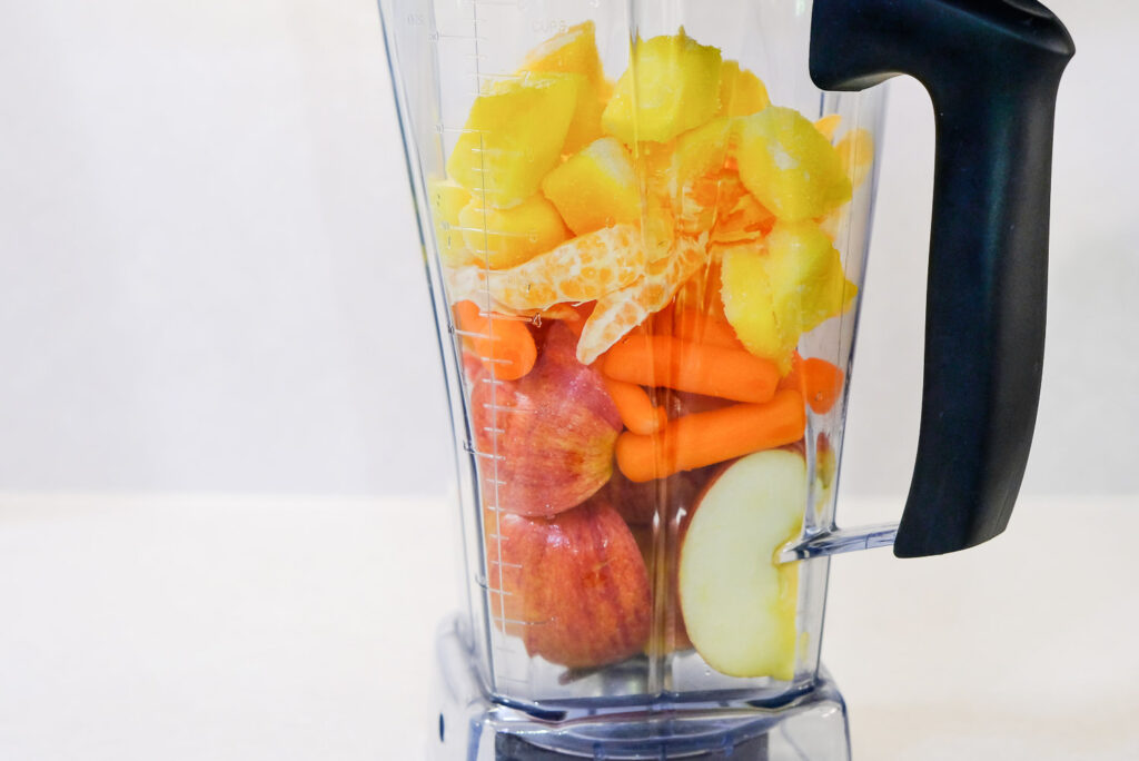 layered fruits and veggies in a blender