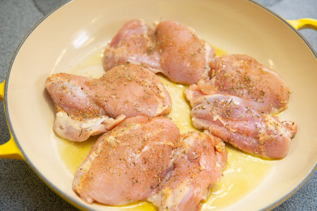 chicken thighs cooking in a pan