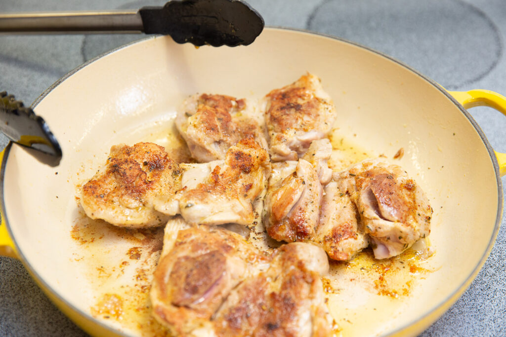 chicken thighs cooking in a pan