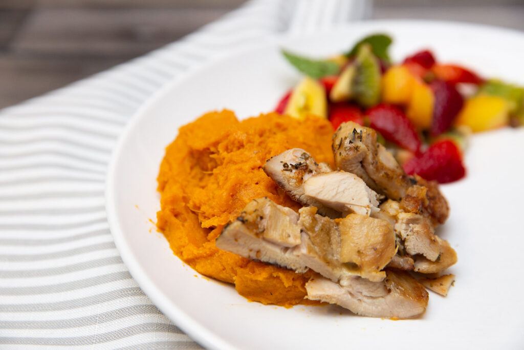 slices of chicken on a bed of mashed sweet potatoes