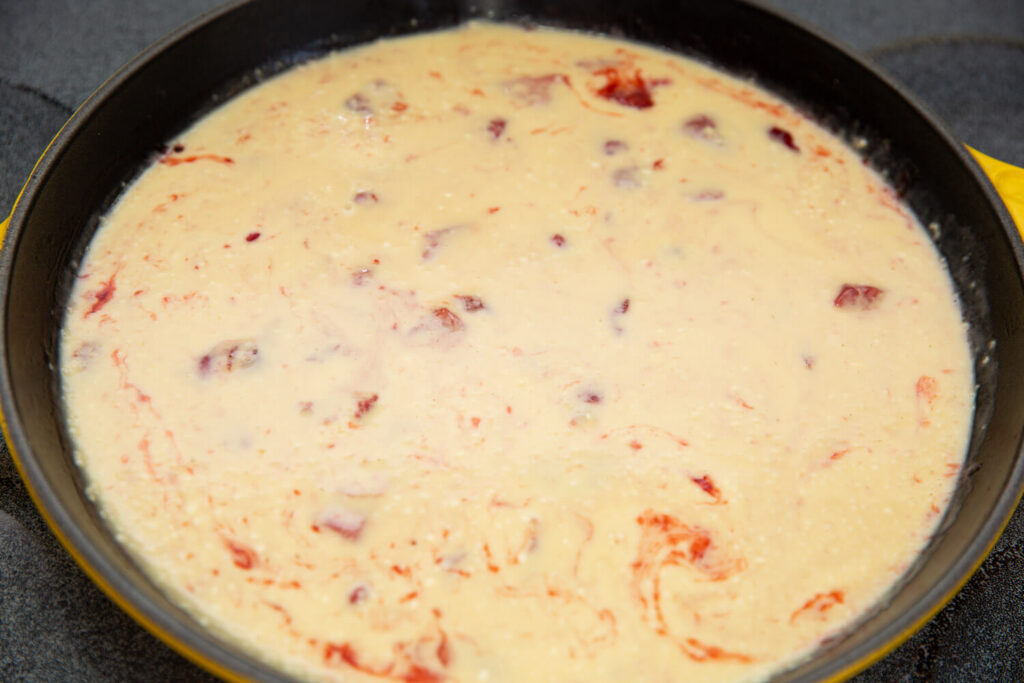 strawberries and batter in a yellow skillet